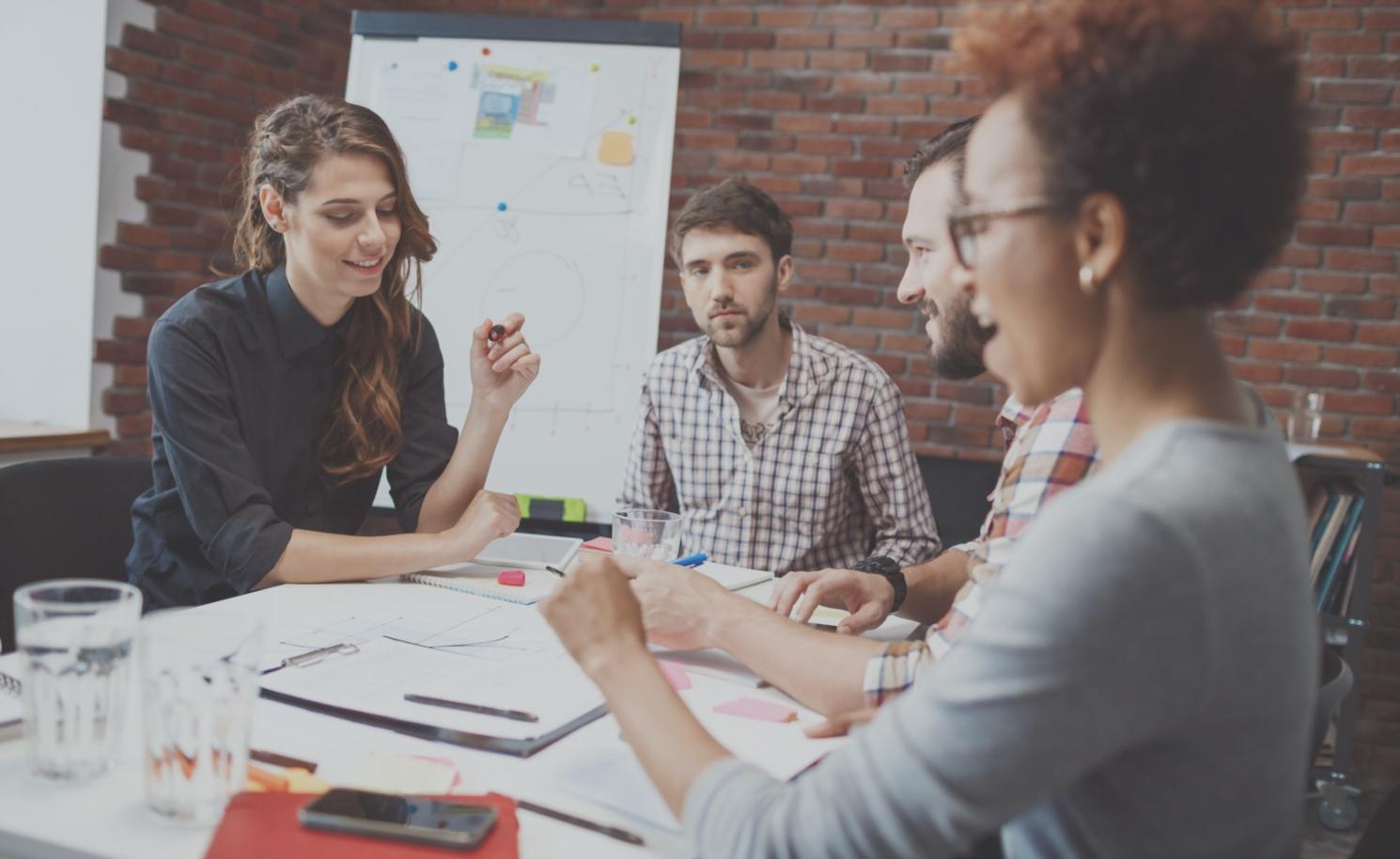 Reunión de análisis financiero con documentos y gráficos en mesa de trabajo